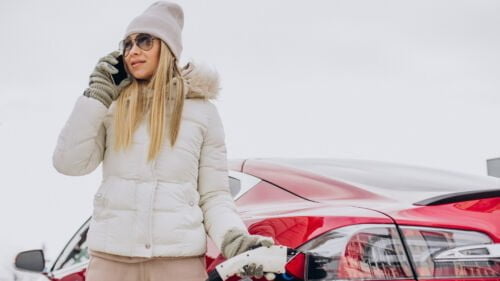 Wszystkie wiadomości - woman charging red electro car winter time