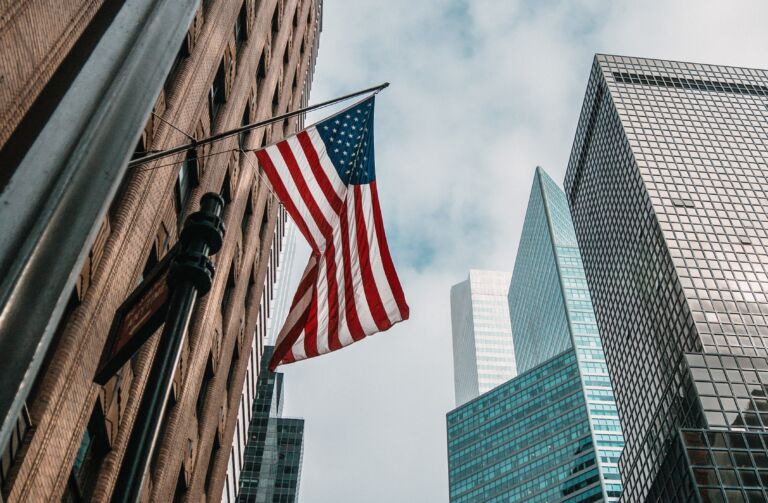 Wszystkie wiadomości - usa united states america flag flagpole near skyscrapers cloudy sky