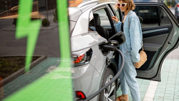 Strefa Wiedzy - woman charging electric car while shopping
