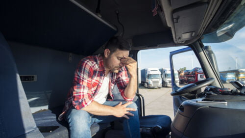 Wszystkie wiadomości - kierowca ciezarowki siedzacy w kabinie ciezarowki zmartwiony i zdenerwowany1