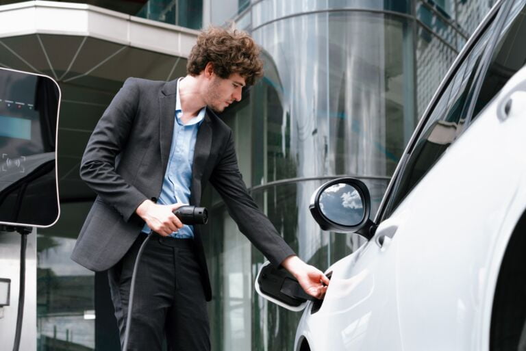 Wszystkie wiadomości - view closeup progressive black suit businessman recharge battery ev car