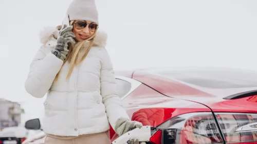 Wszystkie wiadomości - woman charging red electro car winter time jpg