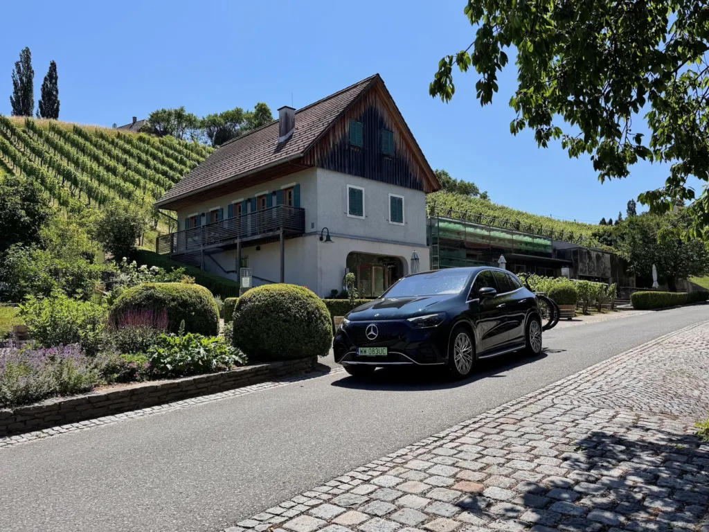 Samochód elektryczny Mercedes EQE SUV przed winnicą Polz w Austrii