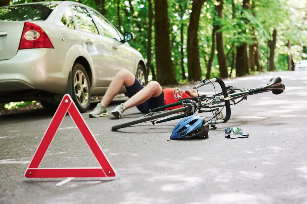 Polska świętuje Światowy Dzień Roweru i wprowadza nowe przepisy. 3 czerwca zmienia zasady gry na drogach - man lying down victim asphalt bicycle silver colored car accident road forest daytime