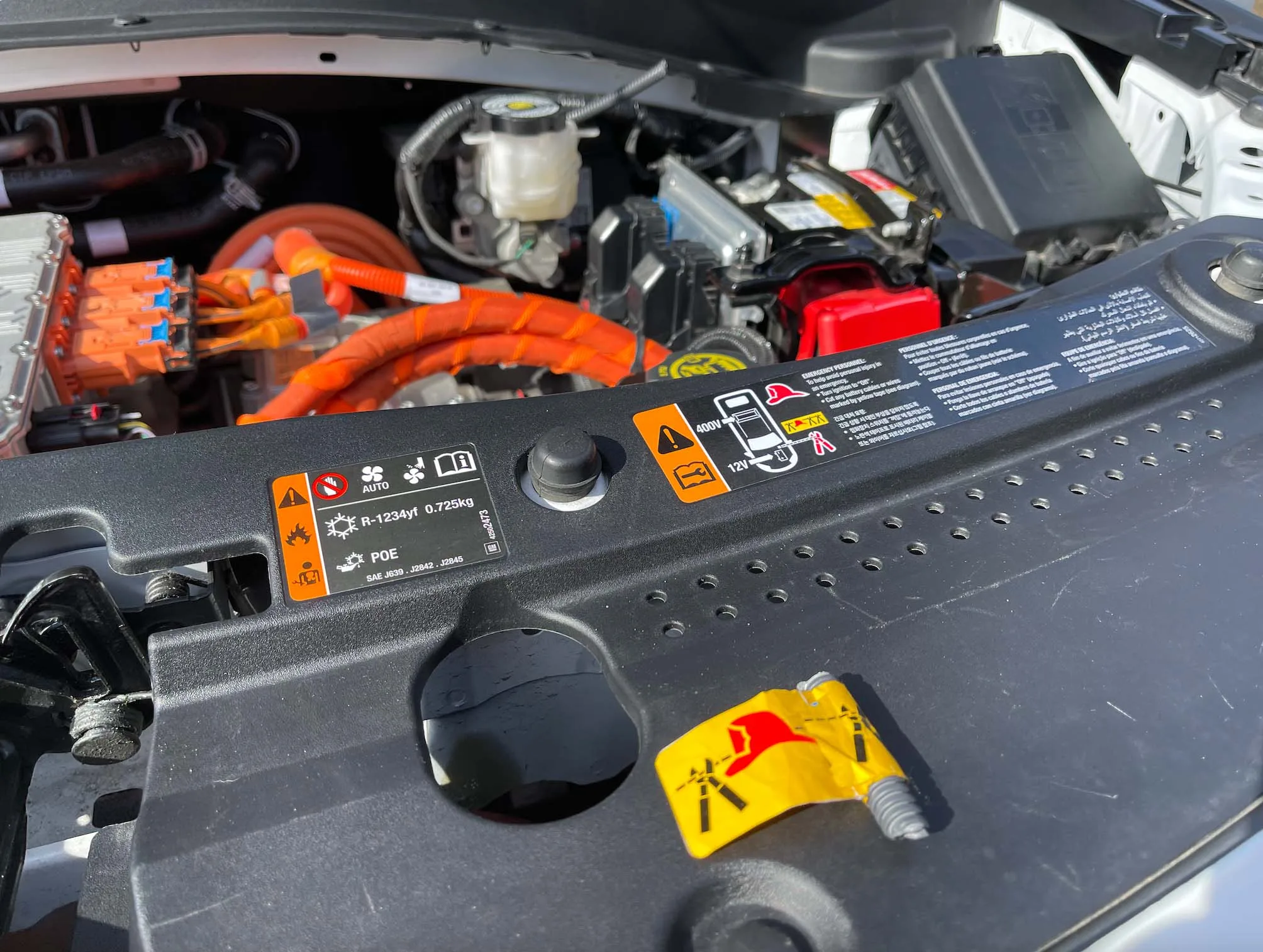 A yellow sticker provides guidance on where to disable a vehicle’s standard 12-volt circuit and is a new industry practice to aid first responders. GM’s training includes guidance on doing this more sparingly to keep battery management systems active.